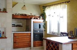 Element zabudowy przy oknie kryje piekarnik i mikrofalówkę