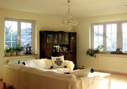 Salon oświetla słońce z okien wychodzących na trzy strony świata. Jego wnętrze &quot;urządza&quot; biel w ciepłych odcieniach i kilka pięknych starych mebli