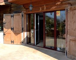 Masywne drewniane okiennice chronią wejście tarasowe oraz wszystkie okna na parterze i piętrze