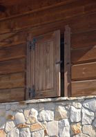 Masywne drewniane okiennice chronią wejście tarasowe oraz wszystkie okna na parterze i piętrze