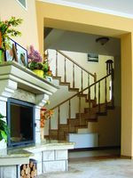 Klatka schodowa tworzy wspólną przestrzeń z salonem, jadalnią i kuchnią.