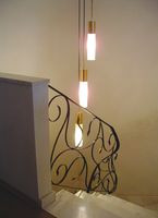 Klatkę schodową wypełnia prosta, nowoczesna lampa