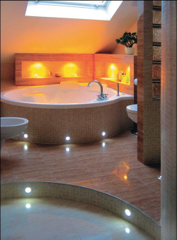 Jeżeli łazienka na poddaszu łączy się z sypialnią i jest miejscem tylko dla małżonków warto przy skośnej ścianie nad oknem umieścić dużą i wygodną wann