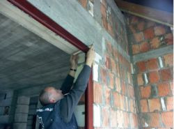 Wstępne mocowanie ościeżnicy w murze za pomocą klinów