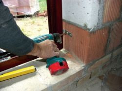 Osadzanie okna w murze za pomocą kotew stalowych