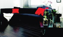 Czarna &ndash; koniecznie lśniąca &ndash; podłoga, do tego ciemne, niskie i rozłożyste meble, białe ściany i sufit &ndash; oto recepta na wizualne podwyższenie salonu