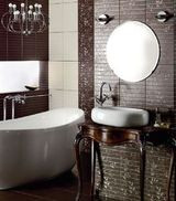 Wysmukła dekoracyjna konsola pod umywalkę czuje się doskonale w otoczeniu eleganckich płytek o subtelnym wzorze