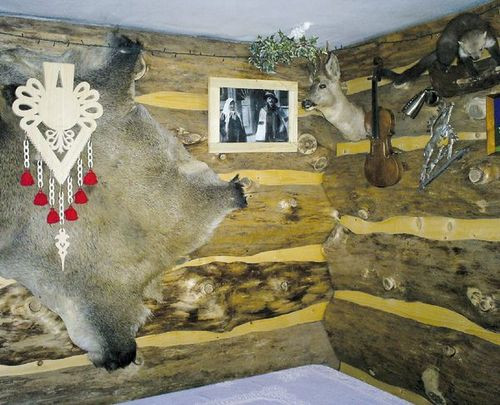 Surową ścianę w jadalni ozdobiono drewnianymi, surowymi deskami, parzenicą i rodzinnymi zdjęciami gospodarzy