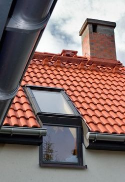 Dach budynku przykryty jest dachówką cementową