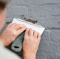 Pęknięcia i ubytki oskrobać szpachlą, nawilżyć wodą używając pędzla i zaszpachlować szpachl&oacute;wką zewnętrzną