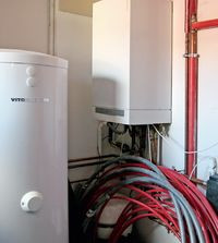 Kocioł kondensacyjny zasila ogrzewanie podłogowe (kuchnia, jadalnia, salon, łazienki, komunikacja i pomieszczenie gospodarcze) oraz grzejniki zainstalowane w sypialniach