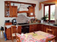 Kuchnia połączona z jadalnią zabudowana jest meblami wykonanymi na zamówienie