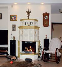Kominek w salonie wykonany jest z kafli, a jego szyba ochronna jest przeważnie podniesiona