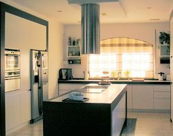 W kuchni zamontowano dużo szafek i długie blaty, a w suficie halogeny