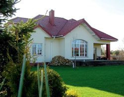 Z tyłu domu zastosowano większe okna i drzwi tarasowe