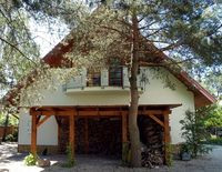 Garaż jest za mały na dwa samochody i zaplecze gospodarcze, dlatego wzdłuż północnej elewacji zbudowano lekką drewnianą wiatę