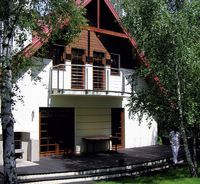 Wzdłuż elewacji południowej, od strony ogrodu, znajduje się taras z drewna egzotycznego