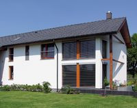 Dom ma prostą bryłę i dwuspadowy dach z oknami połaciowymi