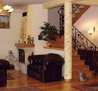 Salon z kominkiem jest połączony z resztą pomieszczeń dziennych