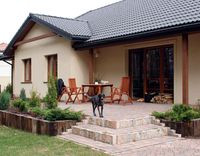 Taras za domem jest połączony z salonem i stanowi ulubione miejsce wypoczynku całej rodziny