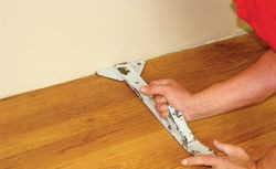 Układanie ostatniego rzędu paneli za pomocą łyżki stolarskiej