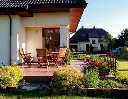 Narożny i częściowo zadaszony taras ma powierzchnię 22 m2. Podłoga wykończona jest mrozoodpornym gresem. Właściciele zamierzają dobudować płytę z kostki brukowej (na poziomie trawnika) na potrzeby większych przyjęć