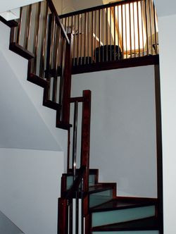 Schody prowadzące na poddasze wykończone są ciemnym drewnem