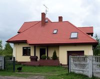 Szukając mądrych oszczędności, pani Renacie zależało, by budynek z garażem miał zwartą bryłę i stanął blisko drogi, w której biegną media. Przyłącza rzeczywiście nie były kosztowne. Betonowy płot mają już wkrótce zasłonić pnącza i żywopłoty