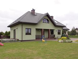 Kolorystyka budynku uwidacznia sentyment właścicielki do zielonego koloru. To ona, jako artysta plastyk, dobierała odcień blachodachówki, którą pokryto kopertowy dach oraz akrylowego tynku na elewacjach. Odcienie zieleni podkreśliła brązową cegłą klinkierową i gresem