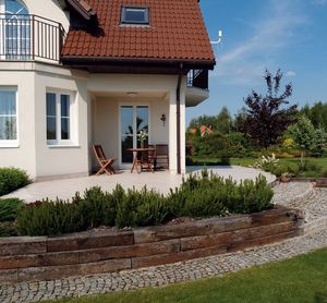 Płyta tarasu została powiększona do 40 m2. Jest wyłożona płytkami klinkierowymi w jasnym kolorze. Schody i ścieżki wokół budynku wykończono kostką granitową. Szkoda tylko, że zadaszona część na tarasie jest tak mała