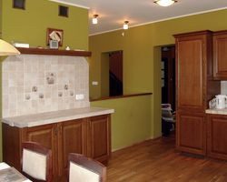 Kuchnia ma optymalną wielkość i sąsiaduje z aneksem jadalnym. Pani Marta narzeka tylko na zbyt małą liczbę blatów roboczych oraz sposób ich wykończenia (kafle na blatach pękają). Wszystkie ściany w strefie dziennej, również w salonie, pomalowała na jednakowy oliwkowy kolor