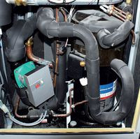 Walcowate urządzenie po prawej stronie to serce pompy ciepła – sprężarka. Zielony element po lewej – pompa obiegowa dolnego źródła (glikolowa)