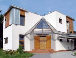 Budynek, choć stoi na tyłach typowego gospodarstwa wiejskiego, ma nowoczesną bryłę z płaskim dachem.