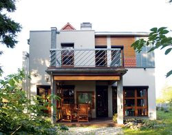 Projektant i inwestorzy w dowcipny sposób zaznaczyli sympatię i przynależność do wiejskiej społeczności. Elewacje wykończyli deskami z modrzewia syberyjskiego, blachą ocynkowaną oraz karpiówką, aby bryła budynku nawiązywała do wiejskiej architektury – zlepka przeróżnych stylów i materiałów