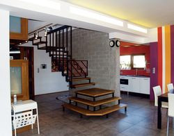 Pan Tomasz lubi kolor pomarańczowy, pani Magda – fiolet. Wybraną przez właścicieli kolorystykę we wnętrzach uzupełnia czerwień, kontrastująca z szarym gresem na podłogach i metalową „przemysłową” klatką schodową