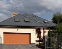 Zwarta bryła domu ma wnęki, załomy i wykusz. Właścicielom zależało, by była ciekawa, ale jednocześnie niedroga w budowie. Kierując się podobnymi kryteriami zaplanowali czterospadowy dach. Starali się zoptymalizować wielkość budynku, by mogli utrzymać go także w przyszłości, na emeryturze