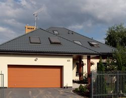 Zwarta bryła domu ma wnęki, załomy i wykusz. Właścicielom zależało, by była ciekawa, ale jednocześnie niedroga w budowie. Kierując się podobnymi kryteriami zaplanowali czterospadowy dach. Starali się zoptymalizować wielkość budynku, by mogli utrzymać go także w przyszłości, na emeryturze