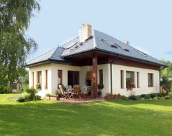 Taras mieści się we wnęce w narożniku budynku. Jest zadaszony i ma widok na intymniejszą część posesji. Podłoga została wykonana z zaimpregnowanych olejowanych desek sosnowych. Jest przez to trwała i antypoślizgowa. Murowany grill przydaje się podczas spotkań w ogrodzie