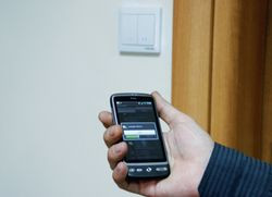 Centrum dowodzenia czyli SmartPhon z darmową aplikacją do zarządzania domem oraz przełącznik ścienny, który wygląda jak zwykły włącznik i tak samo się go montuje. Komunikuje się z każdym urządzeniem Z-Wave za pomocą fal radiowych