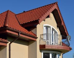 Dom ma łamany dach oraz wykusze z kilku stron. Wybierając gotowy projekt, właściciele rozważali budowę budynku o prostej bryle i dwuspadowym dachu. Jednak ostatecznie zdecydowali się na droższy w budowie, ale bardziej efektowny dom