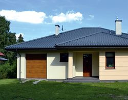 Niski parterowy budynek ma wymiary 14 × 16 m i ładnie dopasował się do wielkości i kształtu niedużej działki.