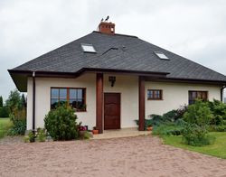 Właściciele chcieli, by dom nie był drogi w budowie i pasował do podmiejskiej wsi. Ma bryłę wystylizowaną na dworek z otwartym gankiem podpartym kolumnami i dachem pokrytym gontem bitumicznym. Ustawili go w odpowiednie dla siebie strony świata. Front budynku skierowany jest na wschód