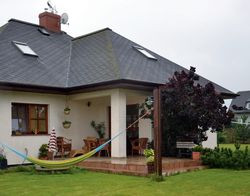 Ważnym parametrem podczas wyboru projektu był duży i zadaszony taras. Pod dachem mieścił się tylko stół, więc właściciele powiększyli nieosłoniętą płytę jeszcze o kilka metrów, by mogli wygodniej wypoczywać. Cieszą się, że taras skierowany jest na zachód, bo nie jest na nim gorąco