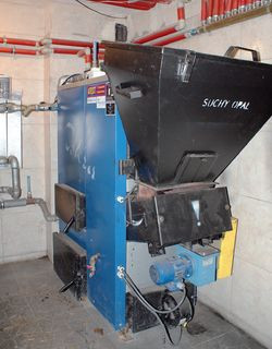 Kocioł na paliwo stałe z podajnikiem tłokowym jest ustawiony w piwnicy