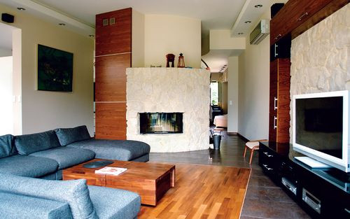 Od strony salonu schody są zasłonięte scianką, na której usytuowany jest kominek