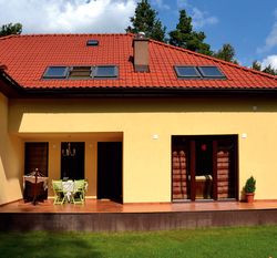 Zadaszona wnęka w załomie murów powstała na życzenie właścicielki. Stoi w niej większość mebli ogrodowych, bo jest tu zacisznie i sucho nawet podczas deszczu. Płyta tarasu, o powierzchni 38 m2 wykończona płytami gresu, powiększa salon i strefę dzienną. To również było celem pani Agnieszki