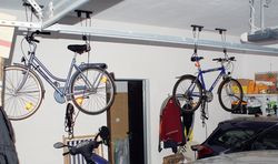 Rowery w garażu wcale nie muszą zajmować zbyt wiele miejsca.W tle widoczne są drzwi do kotłowni