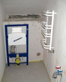 ubikację pod schodami można przekształcić w łazienkę z prawdziwego zdarzenia, jeśli przejście do garażu zostanie przeniesione do wiatrołapu