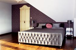 Duża sypialnia na poddaszu z garderobą ukrytą za ozdobnymi drzwiami