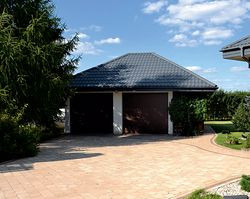 W miejscowości, gdzie osiedlili się Anna i Jarosław działki nie mogą być mniejsze niż 1200 m2. Ta ma 1750 m2, więc zmieścił się na niej wolno stojący garaż. Można też było ukryć zbiornik na gaz płynny. Dodatkowo od strony ogrodu, pod wysuniętym okapem dachu, właściciele zorganizowali miejsce na drewutnię